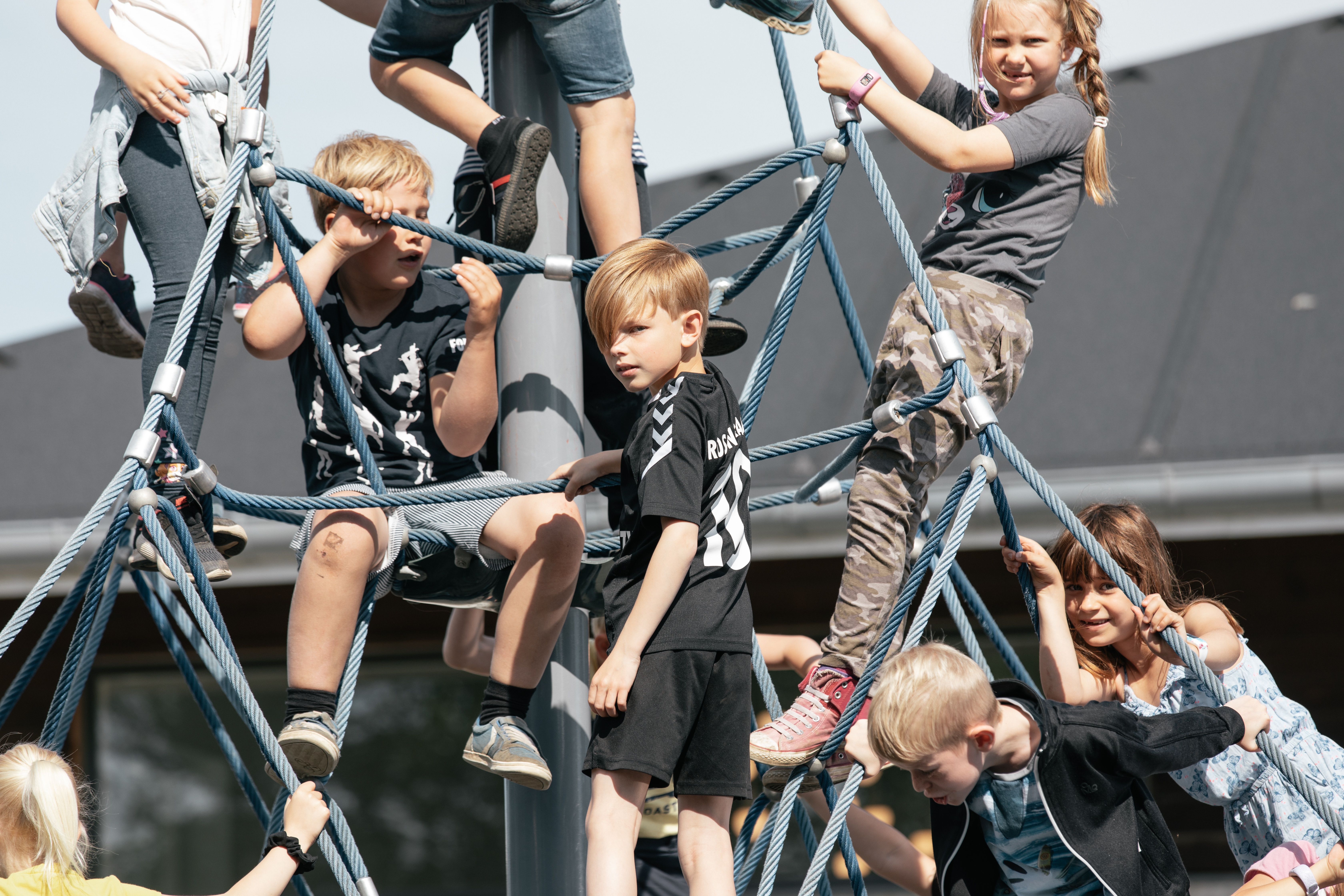 Elever stående og siddende i klatrenettet